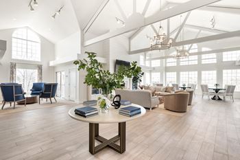 A spacious room with a round table in the center and chairs surrounding it